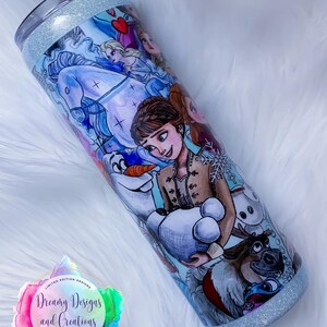 Puede incluir: Un vaso azul claro con acabado brillante presenta una ilustraci&oacute;n colorida de personajes de la pel&iacute;cula animada Frozen. El vaso tiene un fondo blanco con una variedad de personajes, incluyendo Elsa, Anna, Olaf, Kristoff y Sven. El vaso est&aacute; decorado con un logotipo de colores arco&iacute;ris que dice "Dreamy Designs and Creations Custom Gifts & Tasty Treats".