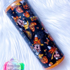 May include: A black and orange tumbler with a Halloween-themed design featuring Mickey Mouse dressed as a witch. The tumbler has a glitter finish and says "Boo!" on the side.