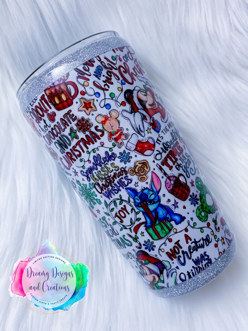 Pu&ograve; includere: Un bicchiere bianco con un bordo di glitter argentato. Il bicchiere &egrave; ricoperto da un design natalizio colorato con Mickey Mouse, Stitch e altri personaggi Disney. Il design include il testo "&Egrave; il periodo pi&ugrave; meraviglioso dell'anno" e "Nessuna creatura si muoveva".