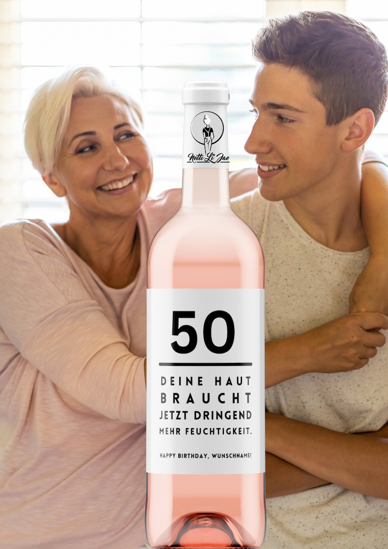 May include: A pink wine bottle with a white label that says "50" and "DEINE HAUT BRAUCHT JETZT DRINGEND MEHR FEUCHTIGKEIT. HAPPY BIRTHDAY, WUNSCHNAME!"