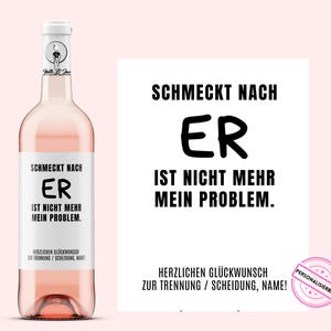 Puede incluir: Una botella de vino rosado con una etiqueta blanca con el texto "SCHMECKT NACH ER IST NICHT MEHR MEIN PROBLEM." Un letrero a juego está al lado de la botella. La botella tiene una tapa blanca.