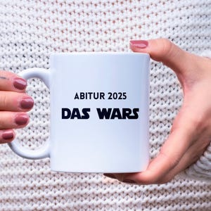 May include: White ceramic mug with a black inscription that reads "Abitur 2025 Das Wars".