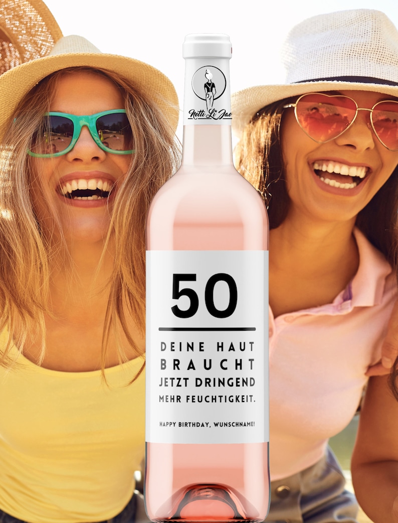 May include: A pink wine bottle with a white label that says "50" in black. The label also says "Deine Haut Braucht Jetzt Dringend Mehr Feuchtigkeit. Happy Birthday, Wunschaname!" in black text.