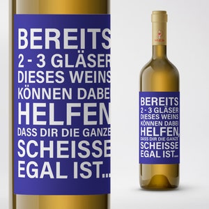 May include: A white wine bottle with a blue label that reads "BEREITS 2-3 GLÄSER DIESES WEINS KÖNNEN DABE HELFEN, DASS DIR DIE GANZE SCHEISSE EGAL IST..."