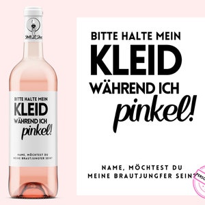 Könnte beinhalten: Eine Flasche rosa Wein mit einem weißen Etikett, auf dem "Bitte halte mein Kleid während ich pinkel!" steht. Das Etikett sagt auch "Name, möchtest du meine Brautjungfer sein?"  Die Flasche steht auf einem weißen Hintergrund.