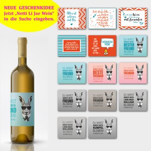 May include: A white wine bottle with a label featuring a cartoon llama wearing sunglasses. The label also includes the text "First Wein und Ben!"  The background shows various colorful cards with German text.
