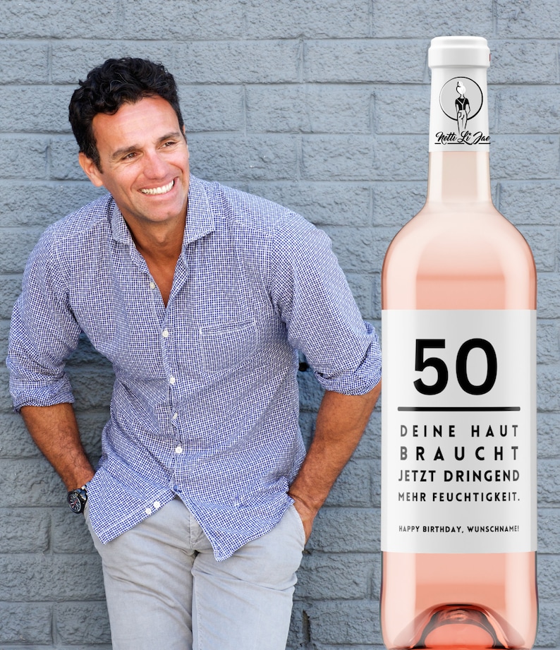 May include: A pink wine bottle with a white label that says "50" and "DEINE HAUT BRAUCHT JETZT DRINGEND MEHR FEUCHTIGKEIT. HAPPY BIRTHDAY, WUNSCHNAME!"