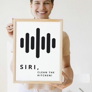 May include: A white framed print with a black sound wave graphic and the text "SIRI, CLEAN THE KITCHEN!"