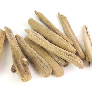 May include: A collection of weathered driftwood pieces in various shapes and sizes. The wood has a natural, light brown color with visible grain and texture. Some pieces have small knots and unique formations, perfect for crafts or decor.