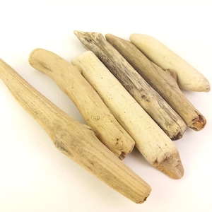 May include: A collection of driftwood pieces in varying shades of tan and beige. The pieces are arranged diagonally, showcasing their natural textures and shapes. Ideal for crafting or home decor.