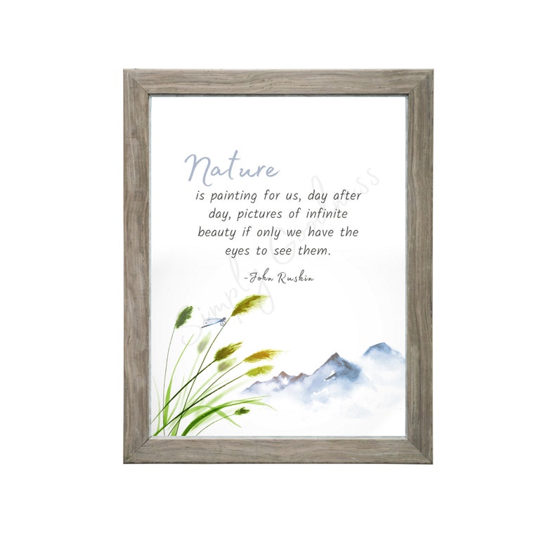 May include: A framed print featuring a watercolor illustration of mountains, grass, and a dragonfly. The print includes the quote "Nature is painting for us..." by John Ruskin in a soft blue font. The frame is a light gray color.