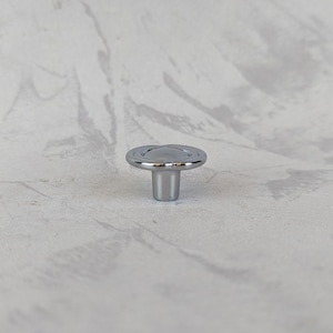 May include: A chrome cabinet knob with a round, slightly raised top and a short, cylindrical stem.