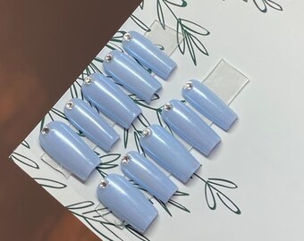 May include: Set of ten light blue coffin-shaped press-on nails with a single clear rhinestone on each nail.