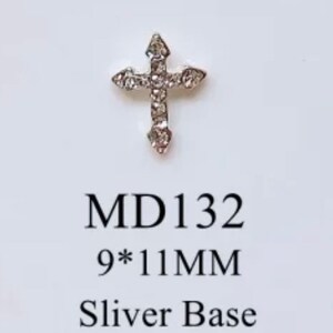 May include: Silver cross with clear rhinestones, measuring 9 by 11 millimeters.  MD 132 Sliver Base.