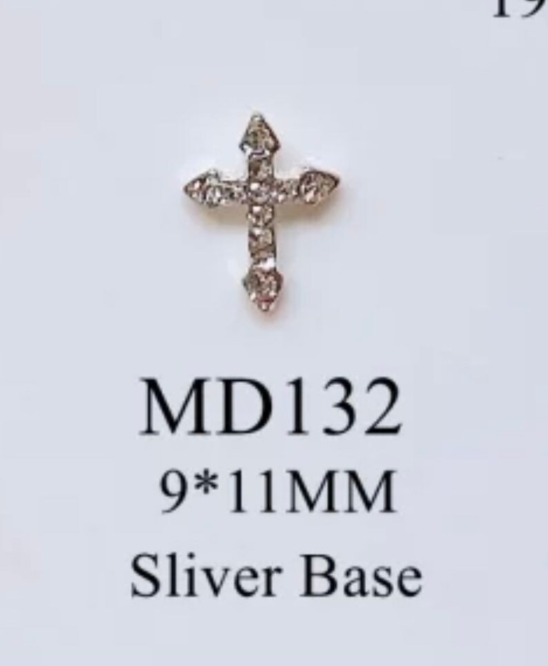 May include: Silver cross with clear rhinestones, measuring 9 by 11 millimeters.  MD 132 Sliver Base.