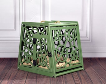 May include: A green wooden dog crate with a decorative lattice design and two doors. The crate has rope handles on the top and a brown cushion inside.