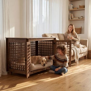 May include: A wooden dog crate with a rectangular design and a grid pattern on the doors. A golden retriever rests inside on a beige dog bed. A child pets the dog, while a woman sits on a couch in the background.