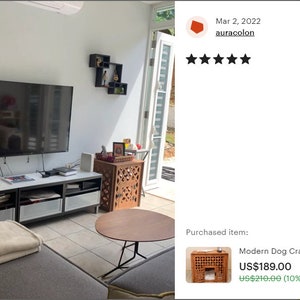 May include: A wooden dog crate featuring a square lattice pattern on the side panels and a rectangular front opening. The crate is constructed from brown wood and includes a flat top surface, providing a functional enclosure for a pet.