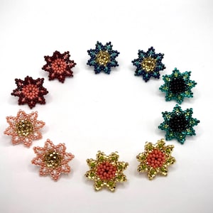 Puede incluir: Surtido de ocho pares de pendientes de estrella con cuentas en varios colores, incluyendo turquesa, verde, rosa y rojo.