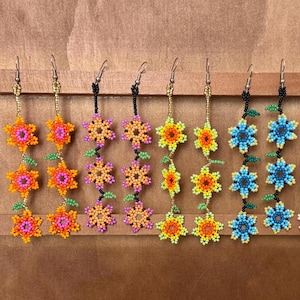 Dinglande blommiga Huichol-pärlformade Chaquira-örhängen med tre blommor