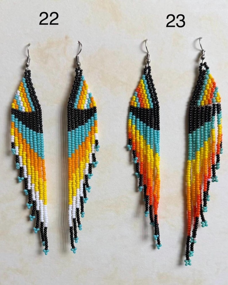 May include: Handmade beaded earrings in a feather design. The earrings feature a black top section, followed by turquoise, yellow, and orange beads. The bottom of the earrings have black and turquoise beads. The earrings are approximately 4 inches long.