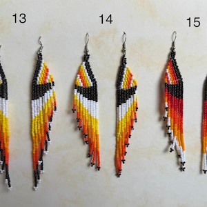 May include: A set of three pairs of beaded earrings. Each earring features a long, fringed design with a black top, and a pattern of white, yellow, orange, and red beads. The earrings are numbered 13, 14, and 15.