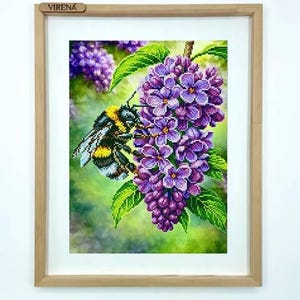 May include: Framed artwork featuring a detailed illustration of a bumblebee on a cluster of purple lilac flowers. The bee has black and yellow stripes. The artwork is in a light brown wooden frame, with the text "VIRENA" on the frame.