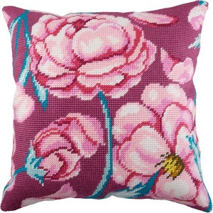 May include: A pink and white floral pillow with a purple background. The pillow features a large pink flower with white petals and a yellow center.
