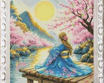 May include: A woman in a blue and pink kimono sits on a wooden dock overlooking a lake. The scene is surrounded by blooming pink cherry blossoms and a bright yellow moon in the sky.