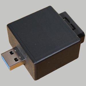 Könnte beinhalten: Ein schwarzer Plastikadapter mit einem USB-C-Anschluss auf der einen Seite und einem USB-A-Anschluss auf der anderen.