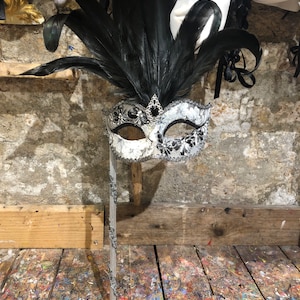 Original Venetian mask for carnival parties with stick hand decorated by expert craftsmen