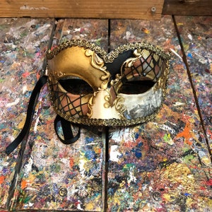 Venetian eye mask decorated with golden colors and Venetian patterns - Venetian carnival mask made and decorated by hand