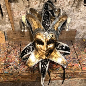 Maschera originale veneziana decorata con foglia  d’argento e carta musicale