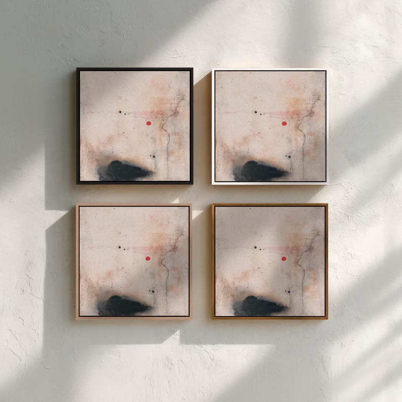 May include: Four framed abstract art prints. Each square print features a neutral background with a dark, cloud-like shape at the bottom, a red dot, and thin black lines. The frames are black, white, and gold.