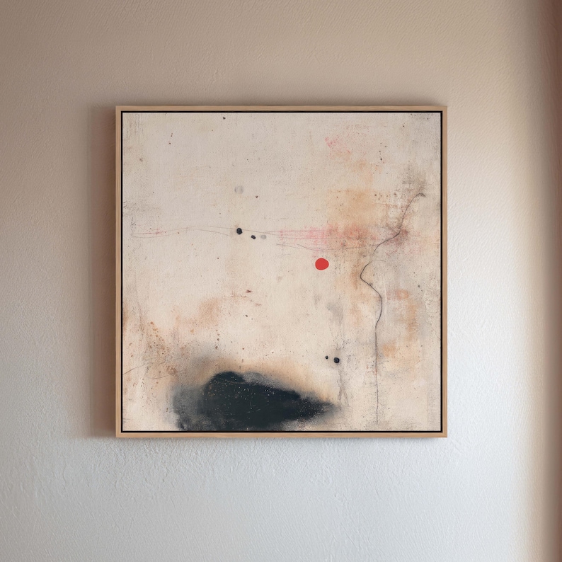 May include: Abstract art piece in a natural wood frame. The artwork features a cream-colored background with black, red, and brown accents. A black cloud-like shape is at the bottom, with a red dot and black dots scattered across the canvas.