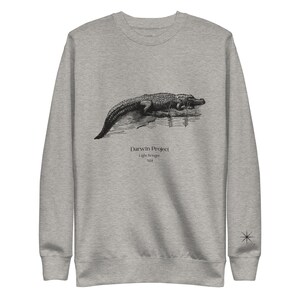 May include: A gray sweatshirt with a black and white illustration of an alligator on the front. The text "Darwin Project Light Bringer 824" is printed below the alligator.