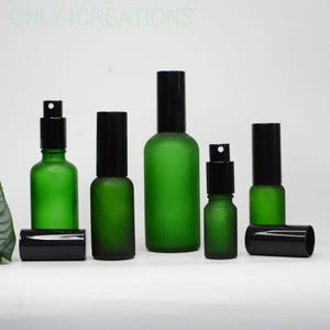 May include: A collection of green glass spray bottles with black caps. The bottles vary in size and shape, with a frosted finish. The text "ONLY4CREATIONS" is visible in the background.