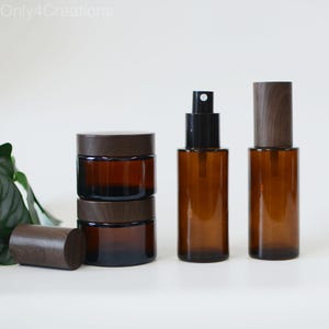 May include: Set of three amber glass bottles with wooden caps. The bottles are of different sizes and shapes. The bottles are ideal for storing essential oils, perfumes, or other liquids.