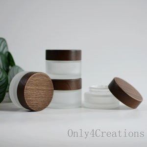 Könnte beinhalten: Glasierte Gläser mit dunkelbraunen Holzdeckeln. Die Gläser sind zylindrisch und in verschiedenen Größen erhältlich, einige gestapelt und andere offen. Die Deckel haben ein Holzmaserungsmuster. Der Text "Only4Creations" ist sichtbar.