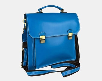 May include: A bright blue leather briefcase with a brown strap and gold clasps. The bag has a top handle and a shoulder strap.