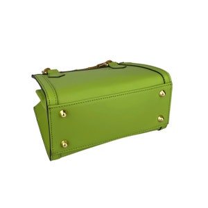 May include: A bright green leather handbag with gold hardware and a top handle. The bag has a rectangular shape and is closed with a zipper.