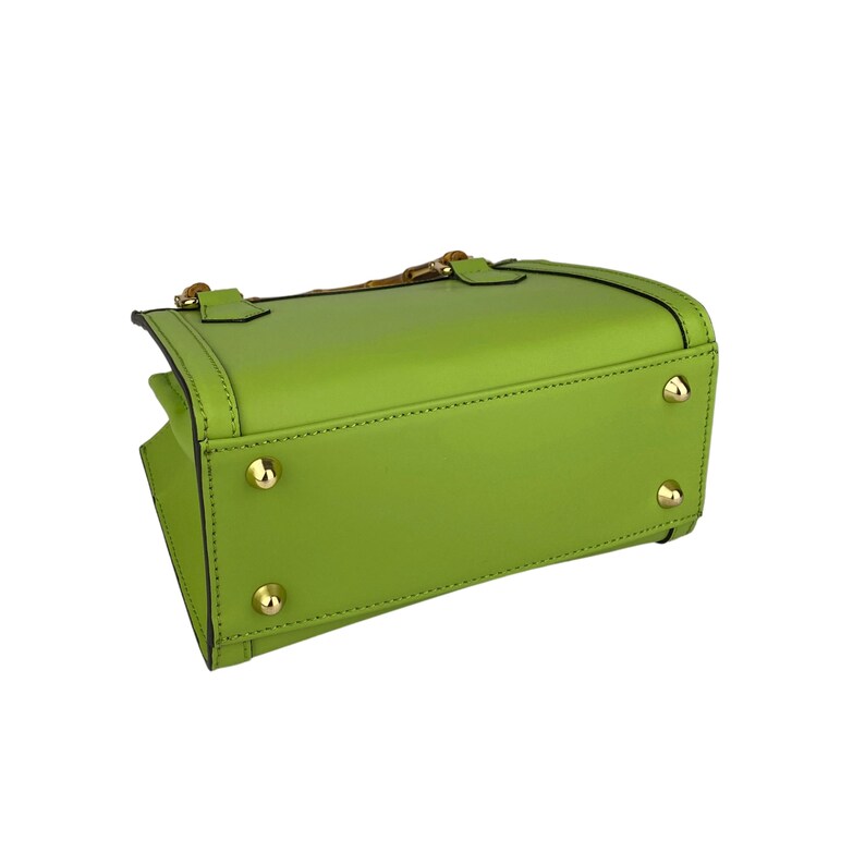 May include: A bright green leather handbag with gold hardware and a top handle. The bag has a rectangular shape and is closed with a zipper.