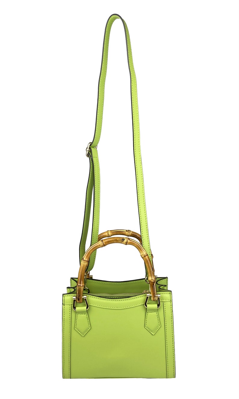 May include: A lime green leather handbag with a bamboo top handle and a long shoulder strap.
