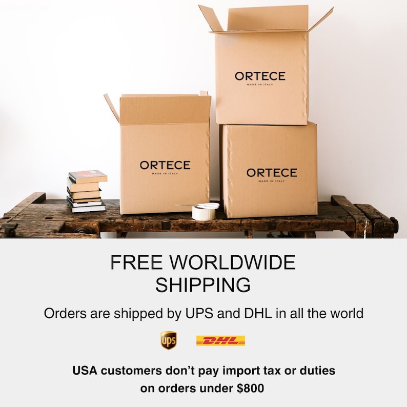 May include: Three cardboard boxes with the brand name "ORTECE" printed on them, stacked on a rustic wooden surface. The boxes are open, suggesting they are ready for shipping. The text "FREE WORLDWIDE SHIPPING" is visible.