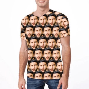 Op de afbeelding: Een wit T-shirt met een herhalend patroon van een mannengezicht met een verraste uitdrukking.