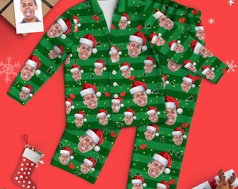 Könnte beinhalten: Grün-rote Weihnachtspyjamas mit einem sich wiederholenden Muster eines Gesichts, das eine Weihnachtsmütze trägt.