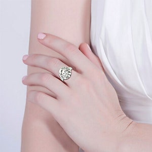 May include: A silver ring featuring a round, raised image of a person's face.