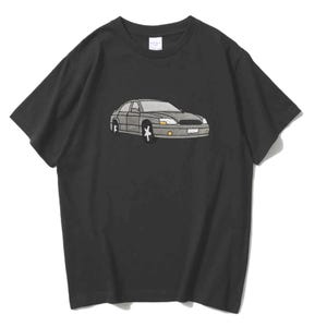 May include: Black t-shirt with a grey sedan graphic. The car illustration has a minimalist design with details like headlights, wheels, and windows. The shirt is made of a soft material and has a crew neck.