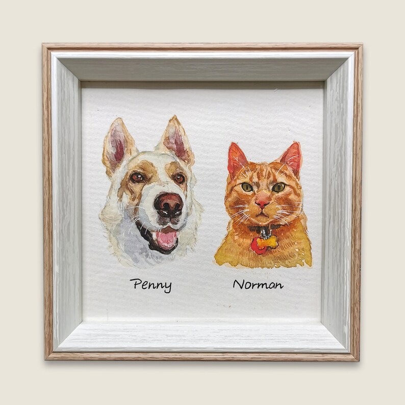 May include: A framed watercolor painting of a white and brown dog and an orange cat. The dog is named Penny and the cat is named Norman.