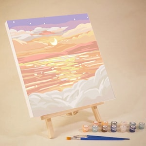 May include: A paint by numbers kit featuring a sunset over a body of water with clouds in the foreground. The kit includes a canvas, paints, and brushes.